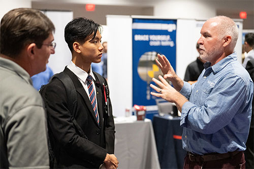 A student talks with employer representatives
