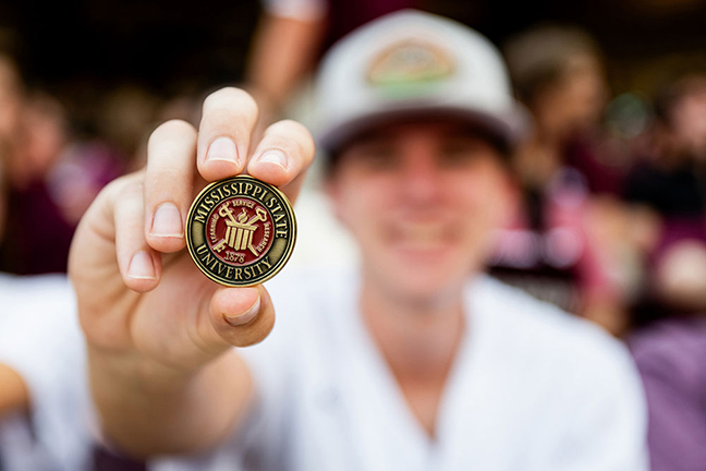 Student holding a commemorative coin