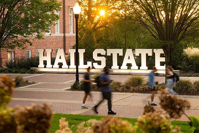 Students walk by the HAILSTATE sign near Montgomery Hall